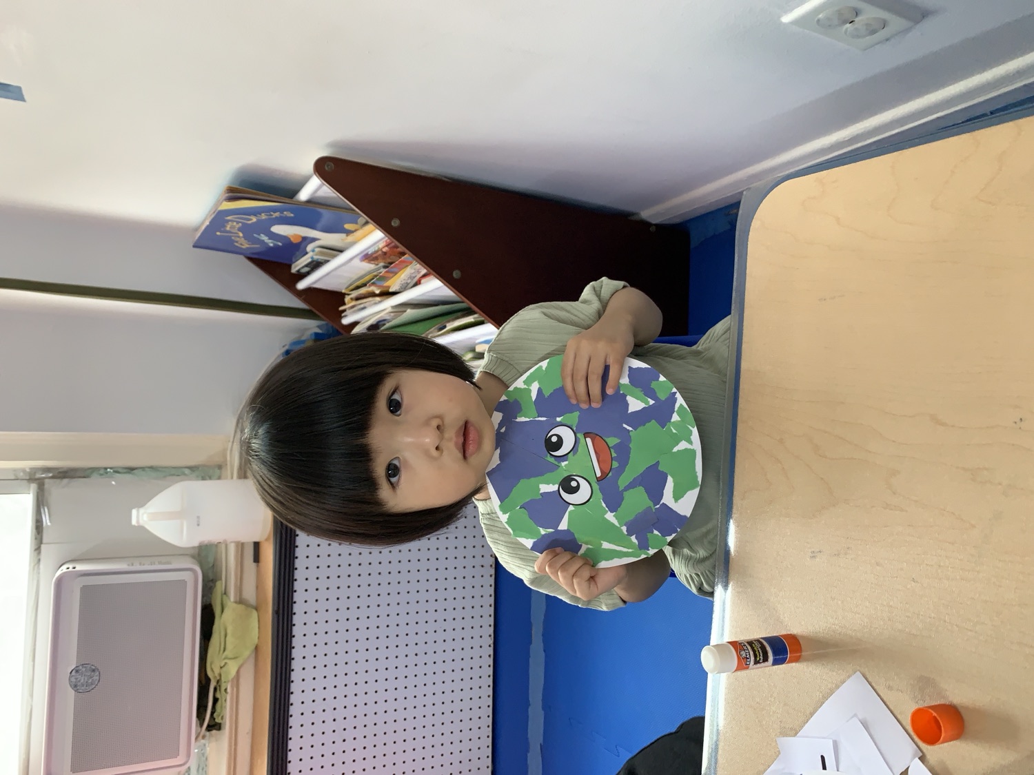 小女孩开心展示自己制作的青蛙手工作品