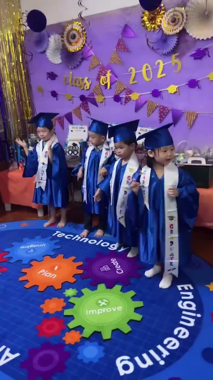 身穿蓝色学士服的小朋友在Class of 2025毕业典礼上欢庆
