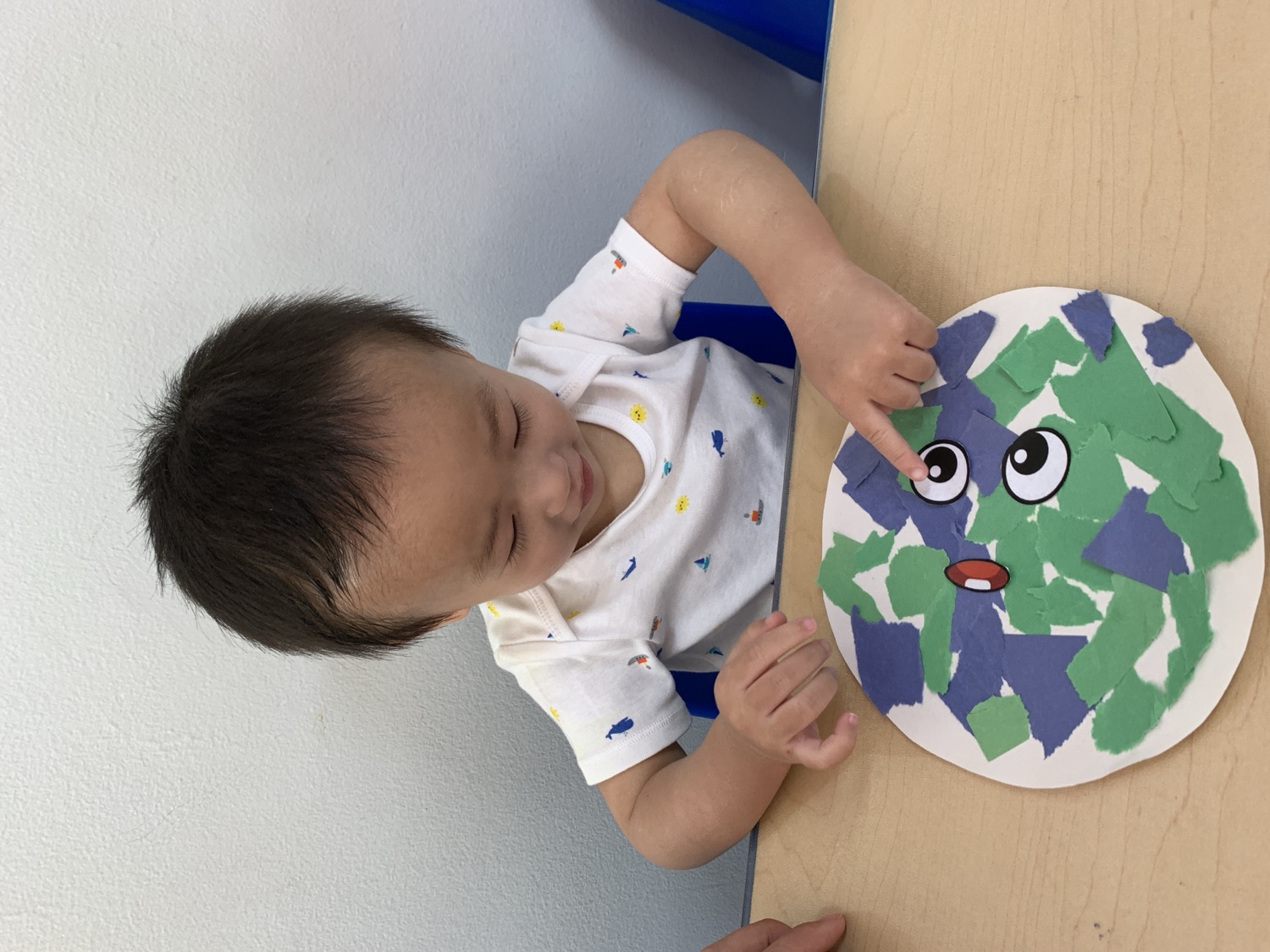 幼儿专注完成地球日主题撕纸贴画